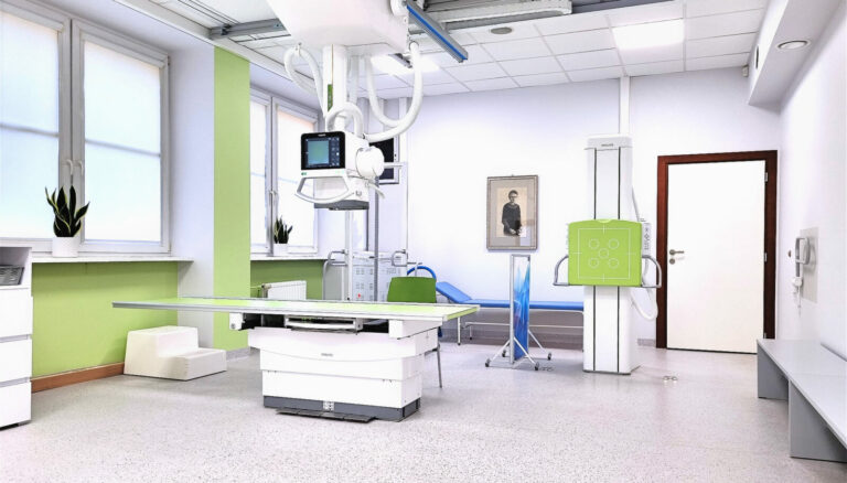 nowoczesny, jasny gabinet rentgenowski z zaawansowanym aparatem RTG, stołem diagnostycznym oraz zielonymi akcentami na ścianach